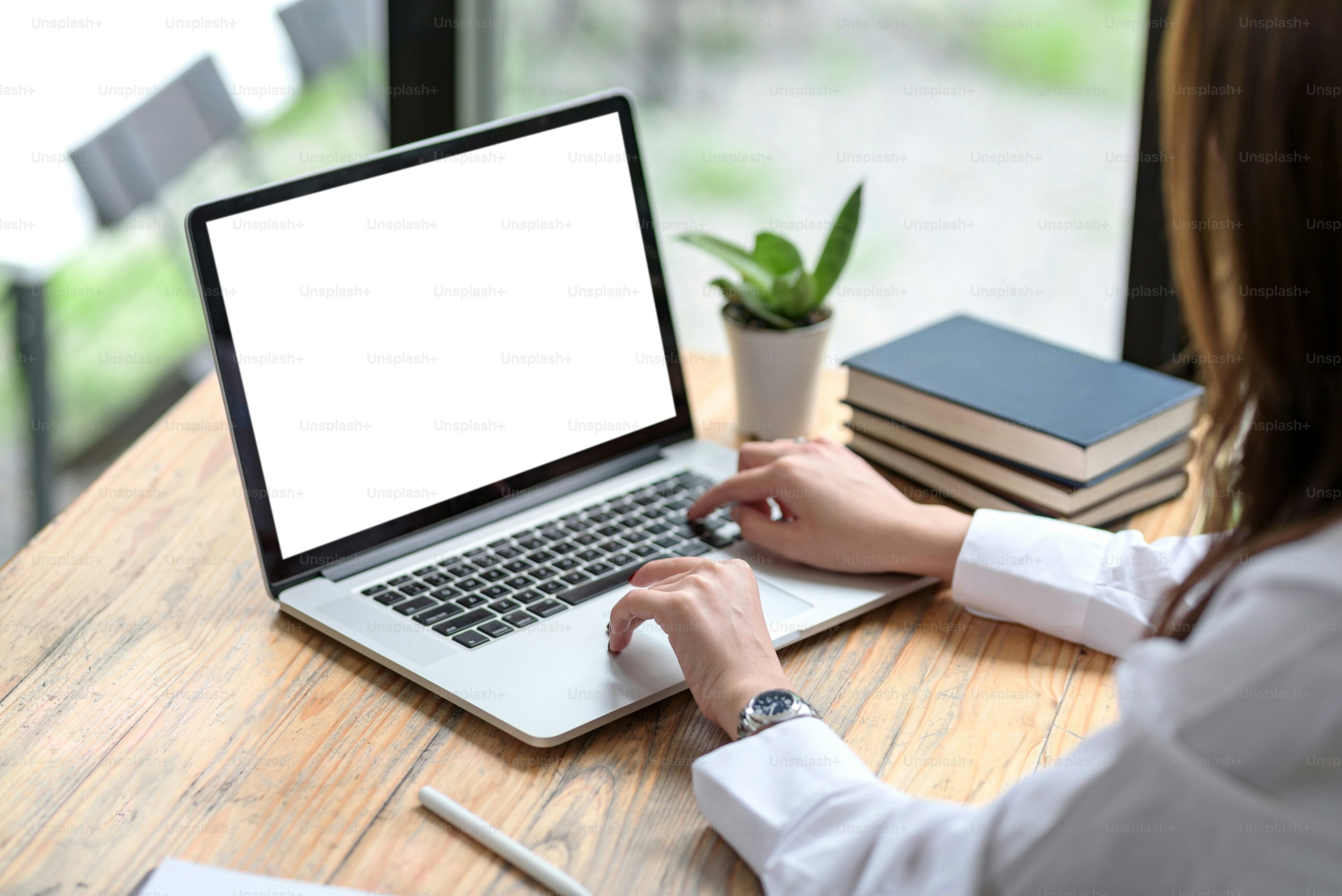 someone typing at a desk on a laptop